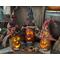 A trio of pumpkin gourds with their whimsical faces lit up. Each has it's own custom witch hat. Their names are Bugsey, Darwin, and Archey. 